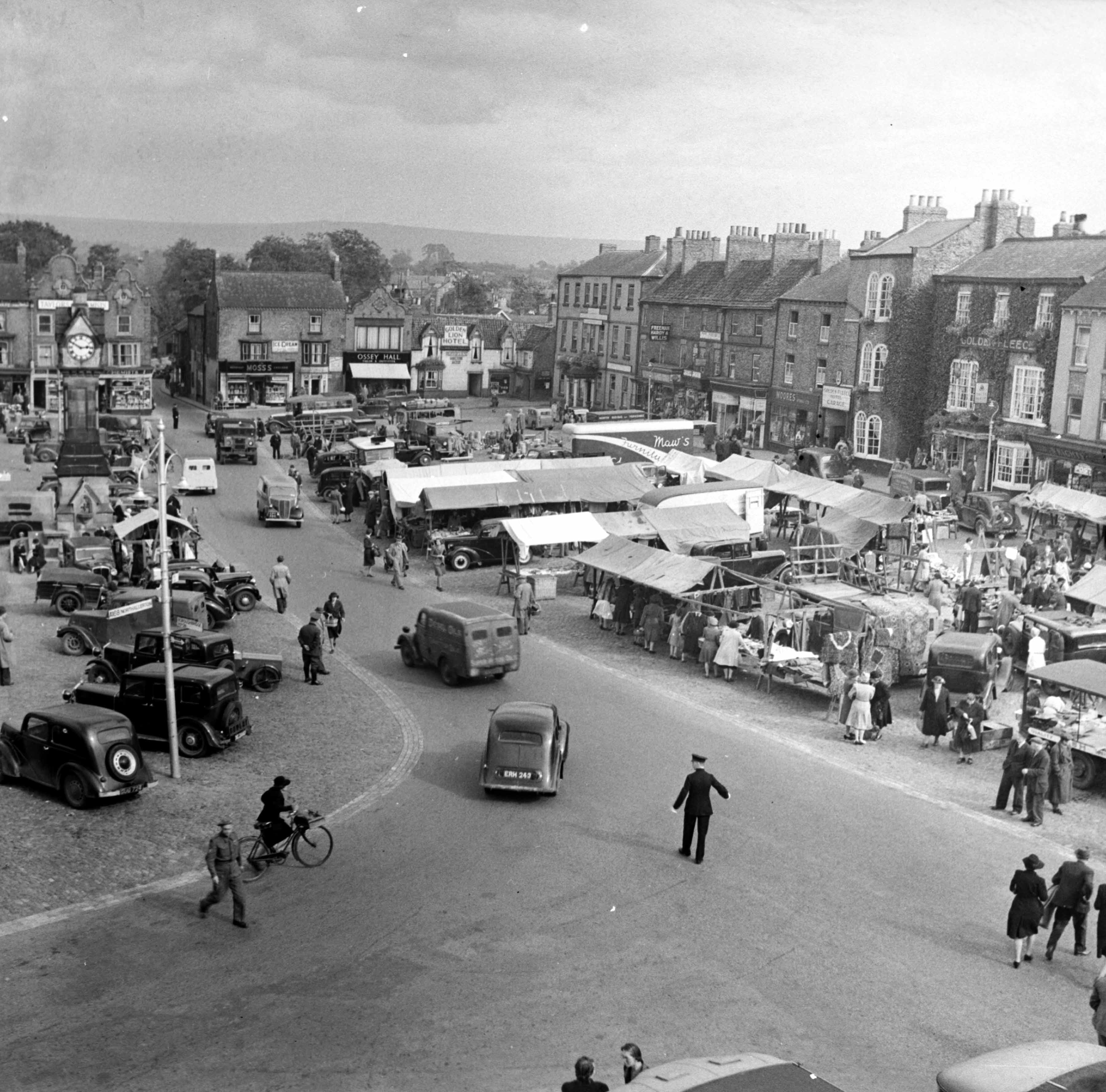 A policeman is directing traffic on a busy market day in Thirsk, c.1940s. Taken by local photographer Bertram Unné, active between 1940 and 1979.