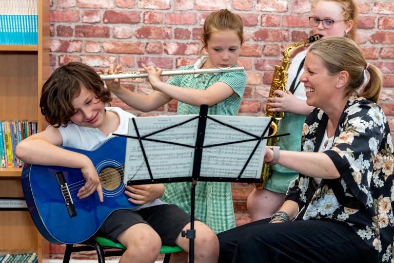 Young North Yorkshire music students playing guitar, flute and saxophone.