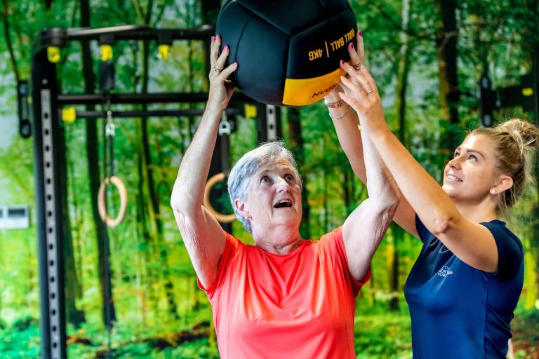 Two ladies with a ball in a gym