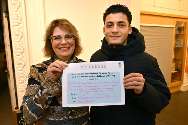 Two people holding a sign