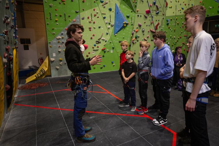 Young people and an instructor at a climbing wall