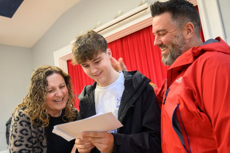 A student with parents looking at GCSE results.