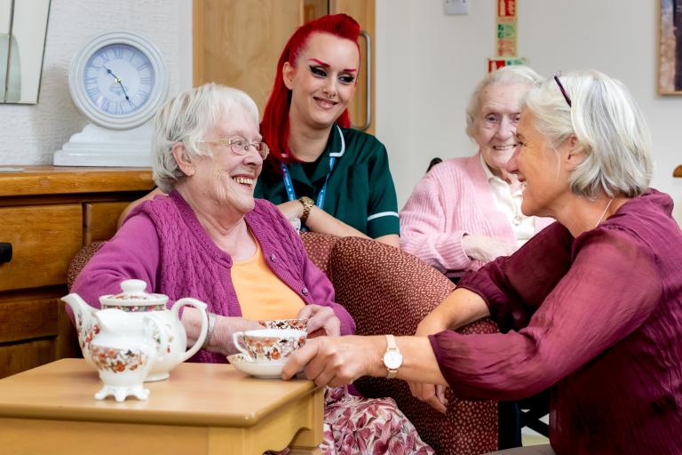 Three older ladies and a care worker