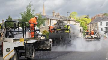 A group of highway workers and machinery