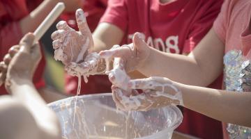 Young people with hands in a bowl