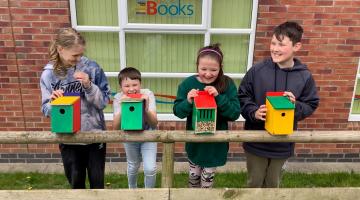 Four children with bird boxes