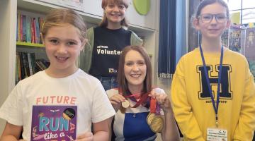 North Yorkshire-based Paralympian and author Danielle Brown wearing her gold medals and an honorary Ready, Set, Read medal, posing with two of Skipton library’s young volunteer Reading Hacks, Beth Kent, 12, and Emily Scott, 16, and Summer Reading Challenge participant Lucy Browne, seven, holding Danielle's book, Run Like a Girl.