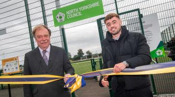 Cllr Simon Myers and professional footballer Alfie McCalmont cut the ribbon to officially open the new 3G pitch and pavilion in Sowerby.