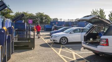 People disposing waste at a household waste recycling centre