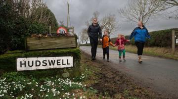 David and Caroline Harper, with their children, Phillip and Lucy walking past the sign for Hudswell