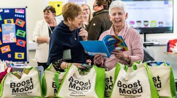 Home library service volunteers, Jennie Leitch (left) and Annabel Garnett, looking through the resources included in the wellbeing bags.