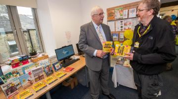 Cllr David Ireton (left) with dementia support advisor at Dementia Forward, Ralph Edwards, alongside the book collection. 