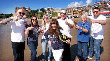The Chef Patron at Clark’s Restaurant, Rob Clark, North Yorkshire Council’s attractions and events delivery manager, Vicki Jones, North Yorkshire Council’s events assistant, Faye Francis, North Yorkshire Council’s member for the Castle division, Cllr Janet Jefferson, North Yorkshire Council’s harbour operations manager, James Buck, Scarborough Maritime Heritage Centre vice chair, Lindy Rowley MBE and North Yorkshire Council’s events assistant, Karl Cammish on Scarborough beach to promote Seafest.