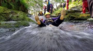 A person sliding along water as part of an Outdoor Learning exercise