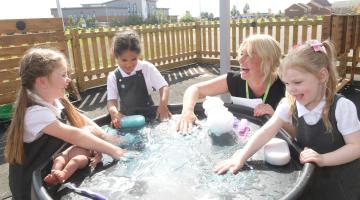 Executive headteacher Nikkie Godbold with new reception pupils from left Ava, Martha and Millie.
