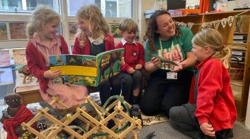 A group of children and a teacher reading