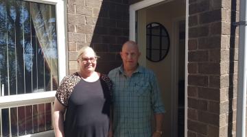 Two people outside a home