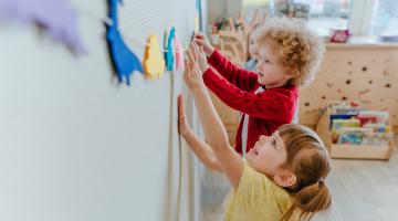 Children sticking animals to a wall
