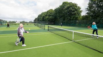 Members of a Rusty Racquets session play a game of tennis on the newly resurfaced courts in Stokesley