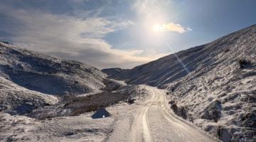 A view of the snow covered road and hills at Askrigg West Moor