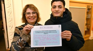 Two people holding a sign