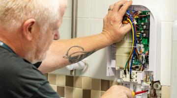 A council maintenance engineer repairing a shower