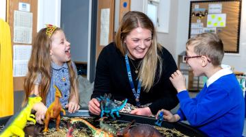 A teacher and two children in school