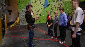 Young people and an instructor at a climbing wall