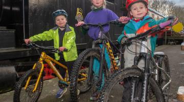 Three young children on a bike