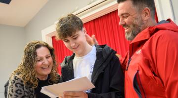 A student with parents looking at GCSE results.