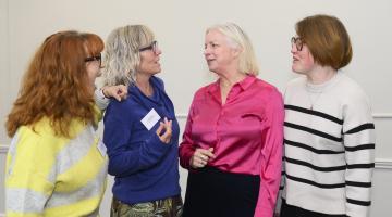 Four ladies stood talking