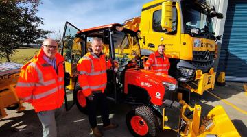 Three men with a gritter and tractor 