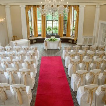 Seats on each side of an aisle ready for a wedding ceremony.