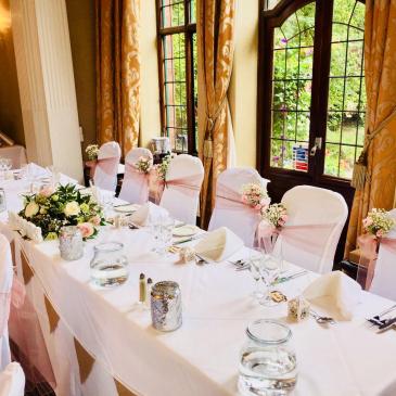 Table and chairs with decorations and a floral centre piece.