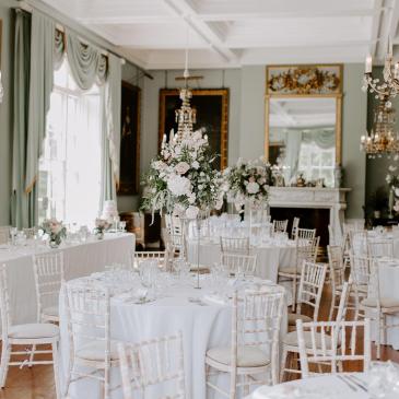 Tables and chairs laid out with decorations for wedding ceremony. 