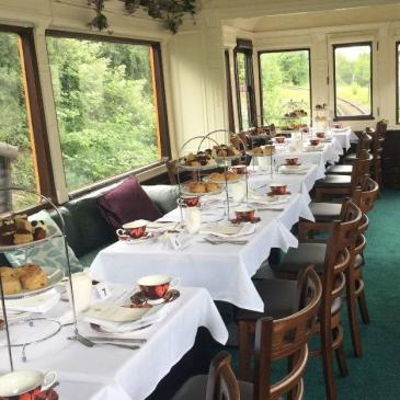 Train carriage with chairs and tables for a wedding meal.