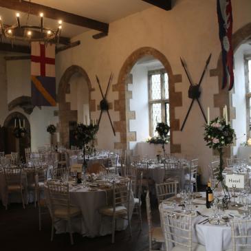 Tables and chairs laid out with floral centre pieces.