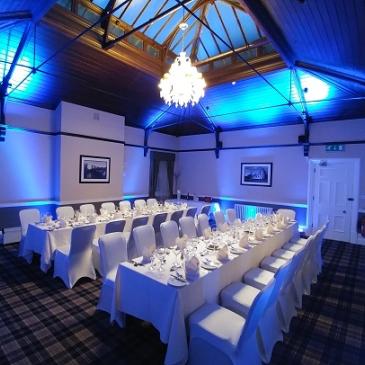 Long tables with chairs on each side set out for a wedding dinner.