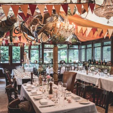 Long table with chairs set for a wedding dinner.