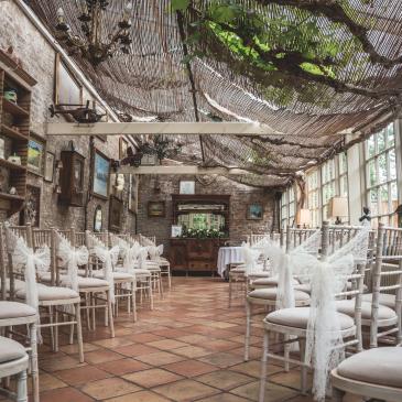 Chairs set out each side of an aisle facing towards the wedding ceremony.