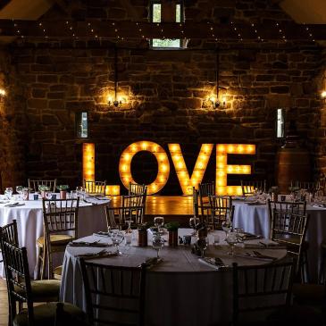 Dining area with lit up love lettering decoration. 