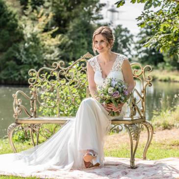 Bride sitting and smiling in her wedding dress.