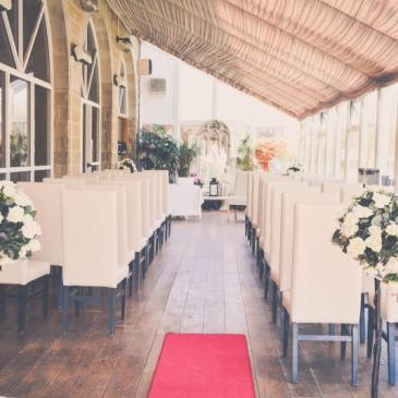 Aisle with chairs and decorations facing ceremony.