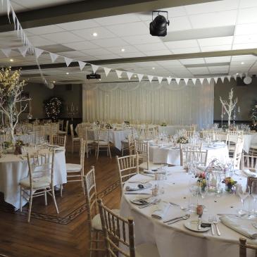 Round tables with chairs set for a wedding dinner.
