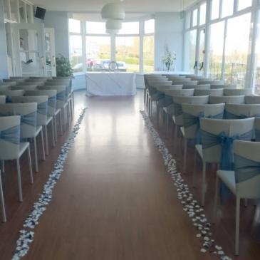 Chairs on each side of an aisle facing towards a ceremony.