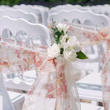 Chairs wrapped in floral ribbons.