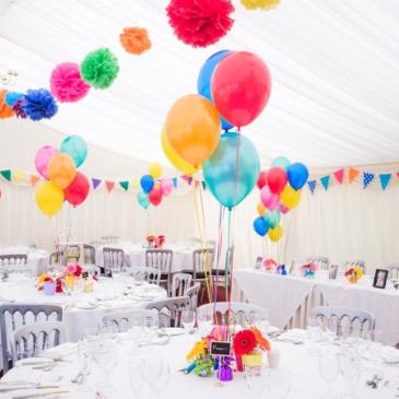 Chairs and tables set out with balloon decorations.