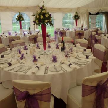Large round tables with chairs and floral centre pieces. 