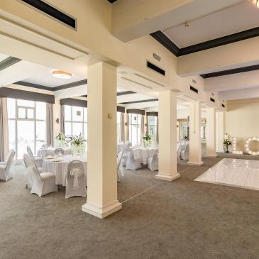 Inside wedding venue with tables and chairs set up
