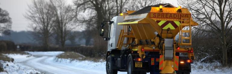 A gritter travelling along a snowy road